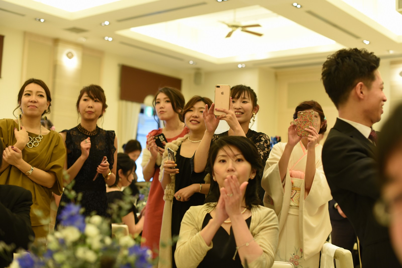 高松市の結婚式場アイルバレクラブでケーキ入刀シーンを撮るゲストの笑顔